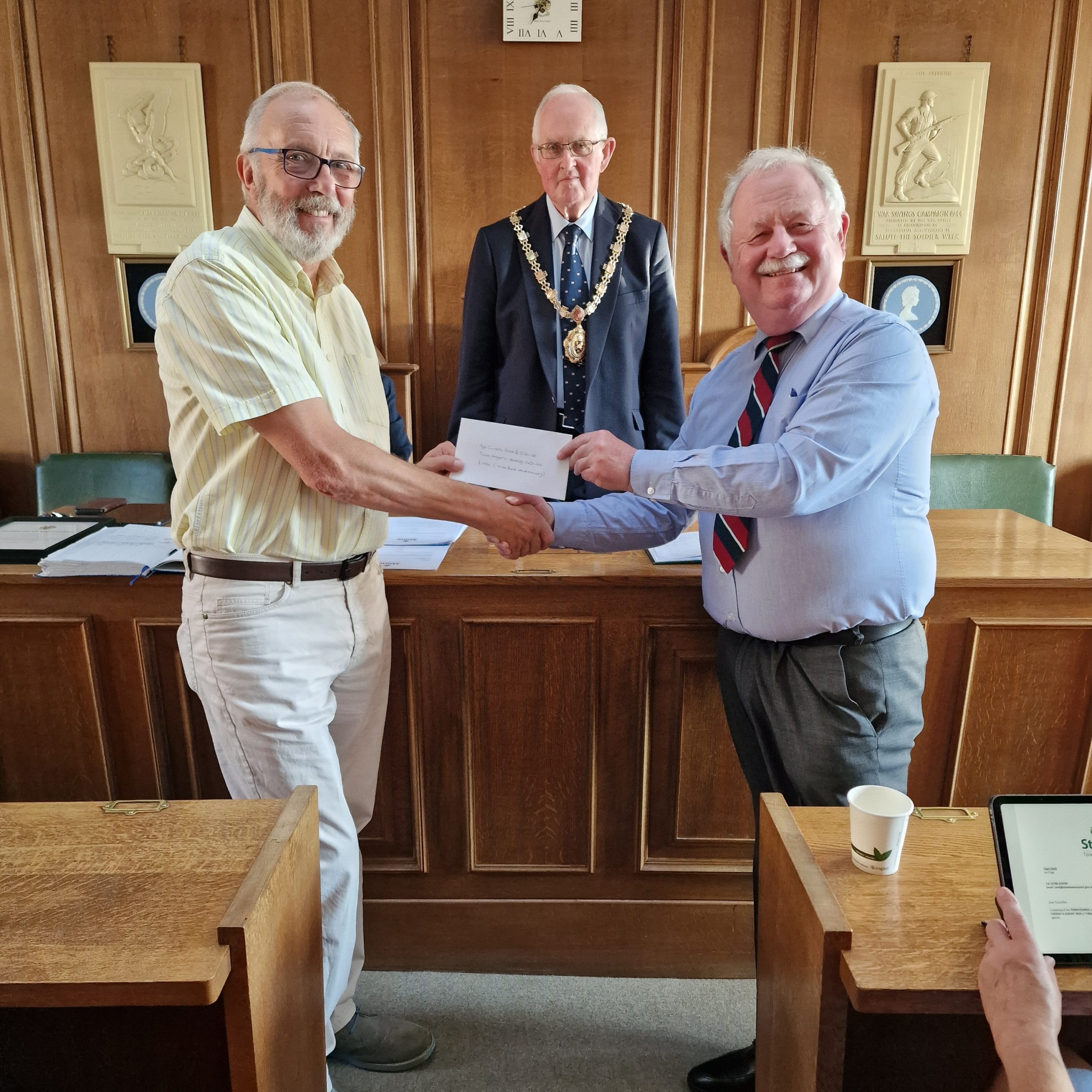 Past Mayor 2023-24, Councillor Jim Davies, awarding Mayor's Charity representative, Neil Norman from Age Concern Stone & District, their share of the funds raised.